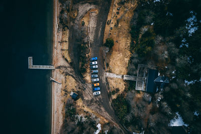 Aerial view of cars parked on road by sea