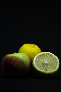 Close-up of oranges on table against black background