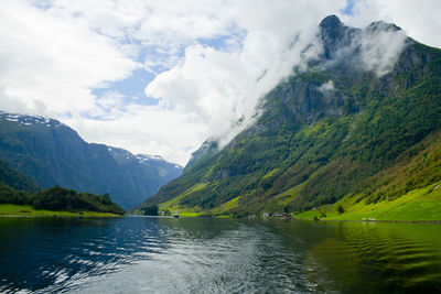 Scenic view of lake by mountains against sky