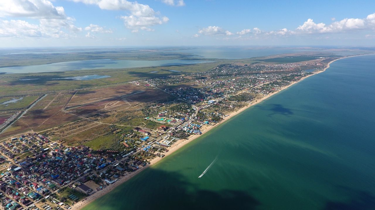 AERIAL VIEW OF SEA AND CITYSCAPE SEEN THROUGH AIRPLANE