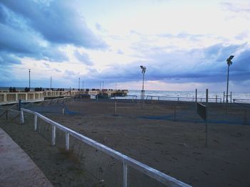 Street by beach against sky in city