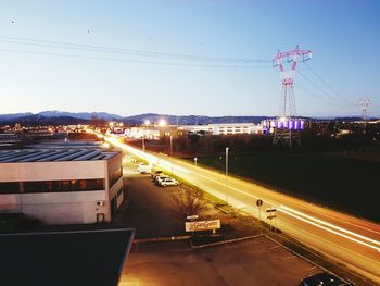 Light trails on road in city against sky at night