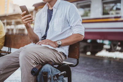 Rear view of man using mobile phone