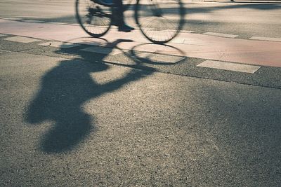 Shadow of man on bicycle in city