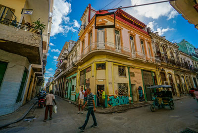 People walking on street amidst buildings in city