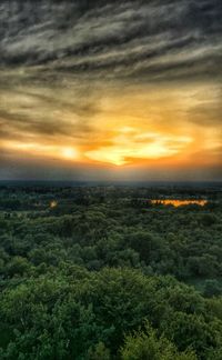 Scenic view of landscape against dramatic sky during sunset