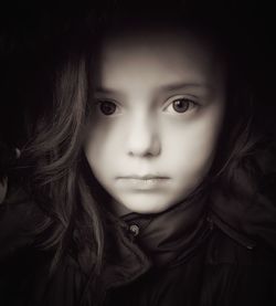 Close-up portrait of cute girl against black background