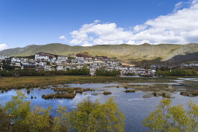 Scenic view of lake by buildings against sky