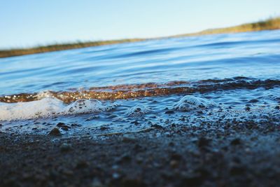 Surface level of calm sea against clear sky