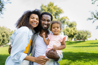 Portrait of smiling friends standing on field