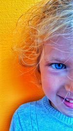 Close-up portrait of smiling girl against wall