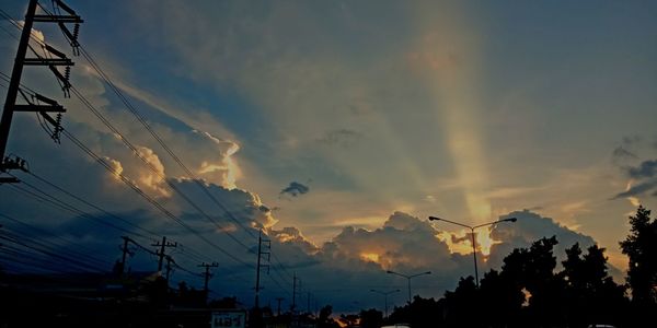 Low angle view of silhouette electricity pylon against sky during sunset