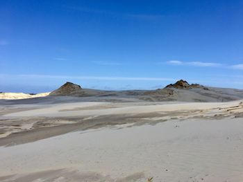 Scenic view of desert against blue sky