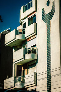 Low angle view of buildings against blue sky on sunny day