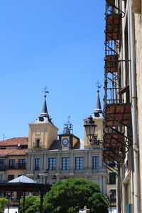 Low angle view of buildings against clear blue sky