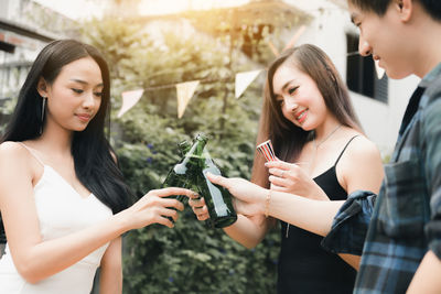 Friends toasting beer bottles during party