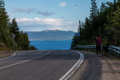 Rear view of man on road against sky