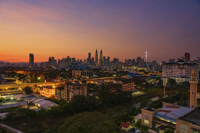 High angle view of city lit up at sunset