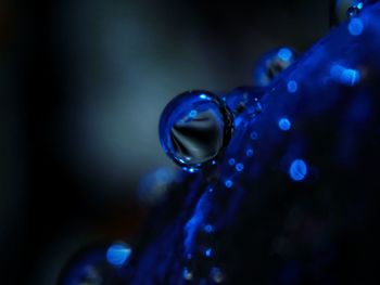 Close-up of water drop on blue surface