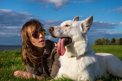 Woman with dog sitting on grass outdoors