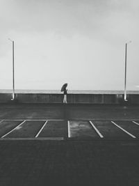 Man on street against sky