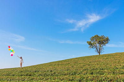Woman standing on field against sky