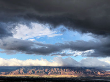 Scenic view of mountains against stormy sky