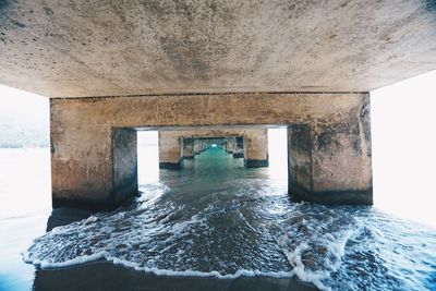 Below view of bridge over sea against sky