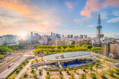 High angle view of city buildings against cloudy sky