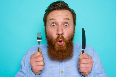 Portrait of man holding blue background