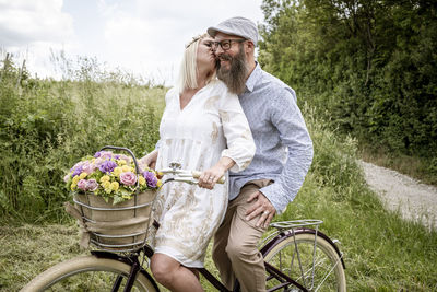 Full length of couple with bicycle against plants