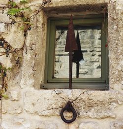 Low angle view of electric lamp hanging on wall of building