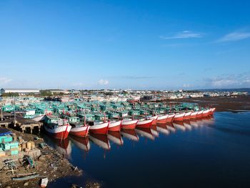 Panoramic view of boats moored in sea against blue sky