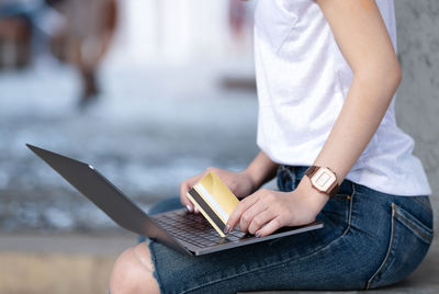 Midsection of woman using mobile phone