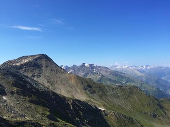 Scenic view of mountains against blue sky