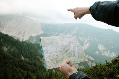 Man holding umbrella on mountain range