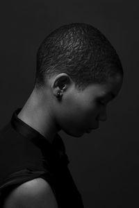 Portrait of young man against black background