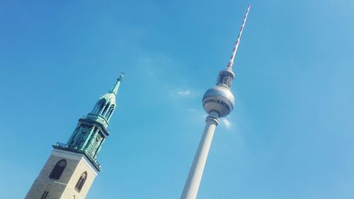 Low angle view of st mary cathedral and fernsehturm against blue sky