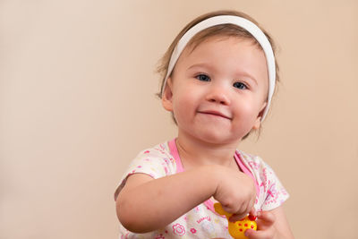 Portrait of smiling girl against gray background