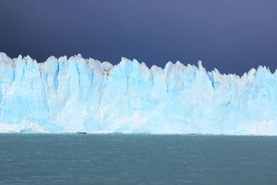 Icebergs and sea against clear sky