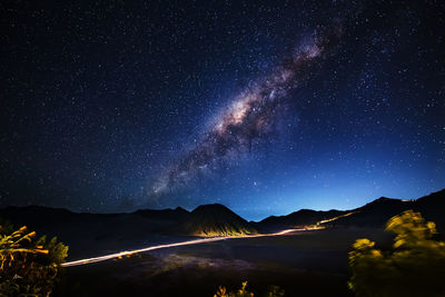 Scenic view of illuminated mountains against sky at night