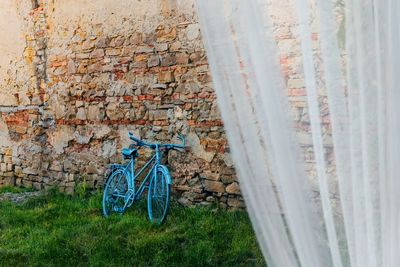 Blue bicycle leaning against wall