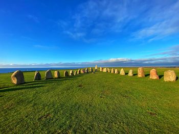 Hay bales on field against sky