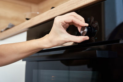 Female choosing program on electric oven panel