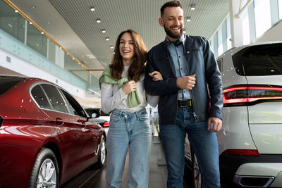 Portrait of smiling couple standing in car