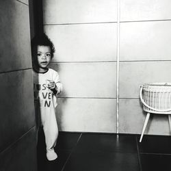 Portrait of girl standing against tiled wall