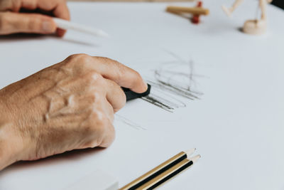 Cropped hand of woman sketching on paper