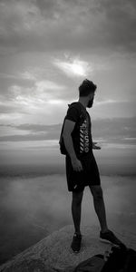 Rear view of man looking at sea against sky