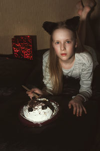 Portrait of girl sitting on table at home