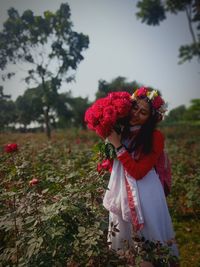 Portrait of woman with red umbrella standing on field